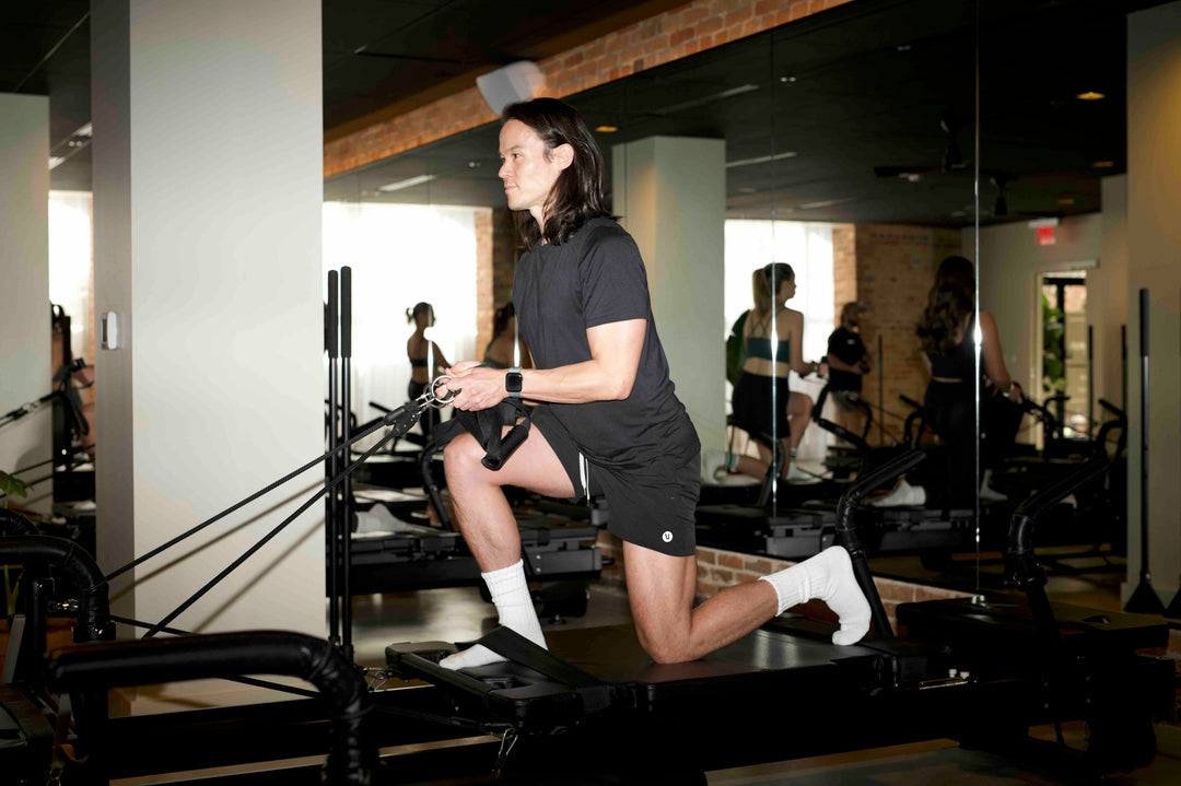 Man exercising on a Pilates reformer machine at FlowCorps