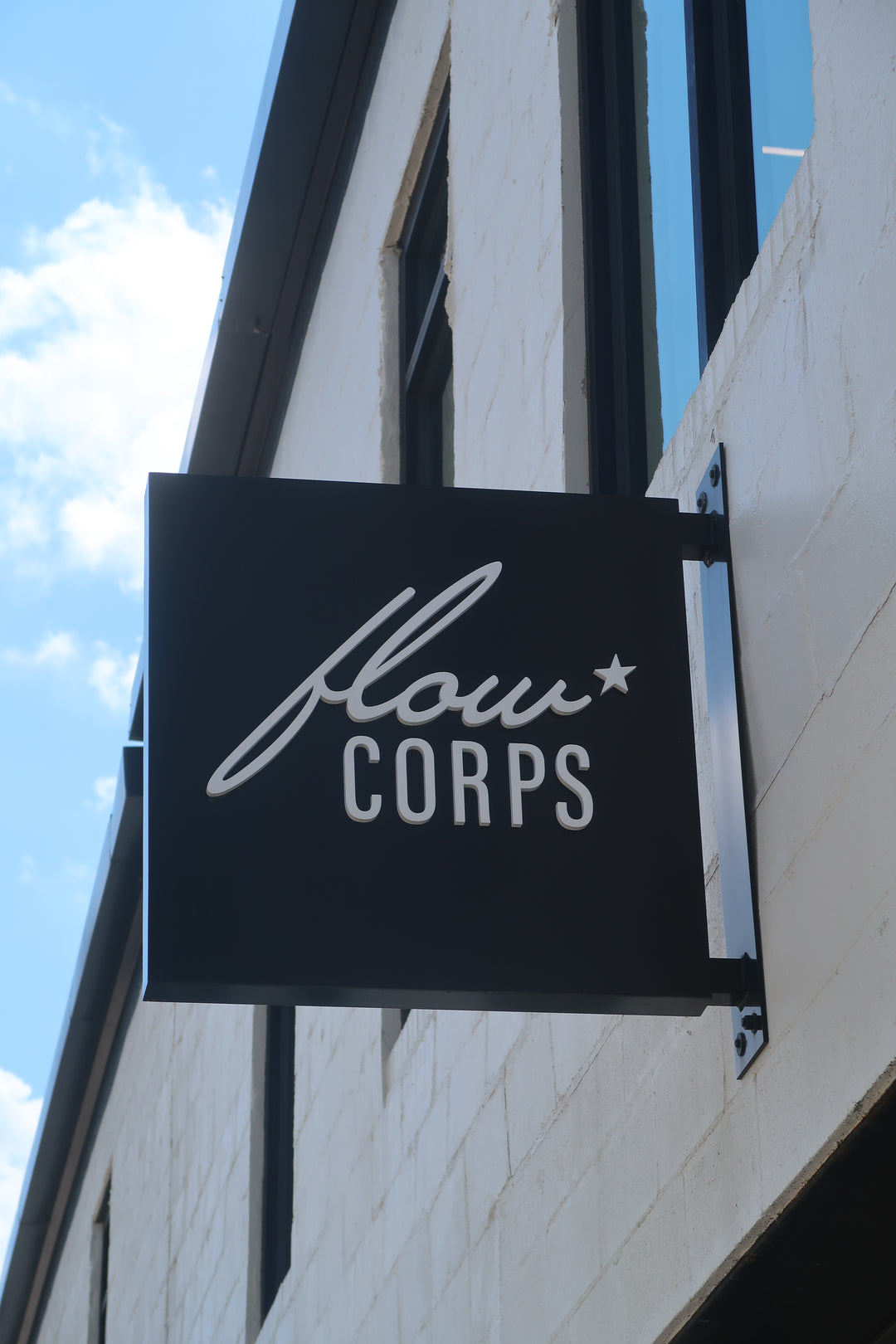 Exterior sign for FlowCorps Pilates Studio at 911 North West Street, Downtown Raleigh NC