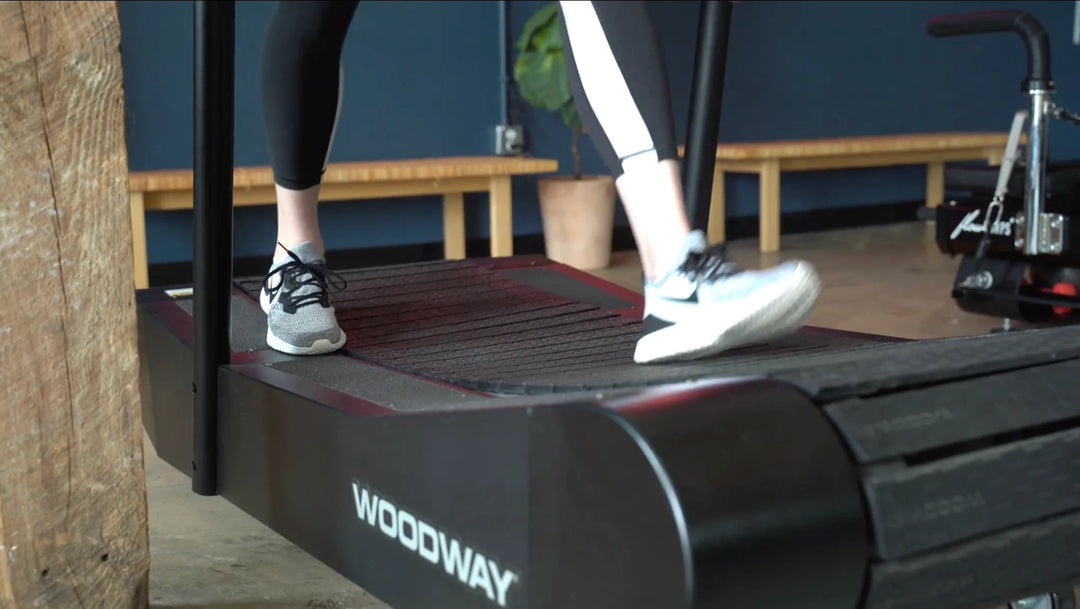 Client walking on a Woodway curved treadmill during a FlowCorps TreadX class